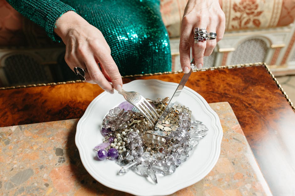 A unique dining setting featuring a plate of gems and jewelry on a marble table.